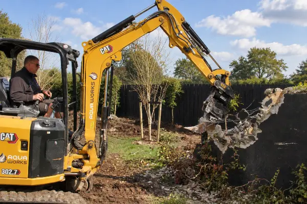 Aqua Work's Digger breaking up an old concrete water tank for removal in Matakana