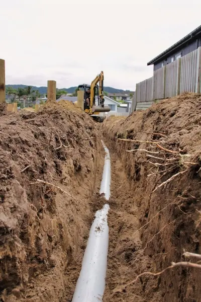 Underground pipework being installed for a new 30,000-litre rainwater tank in Mangawhai