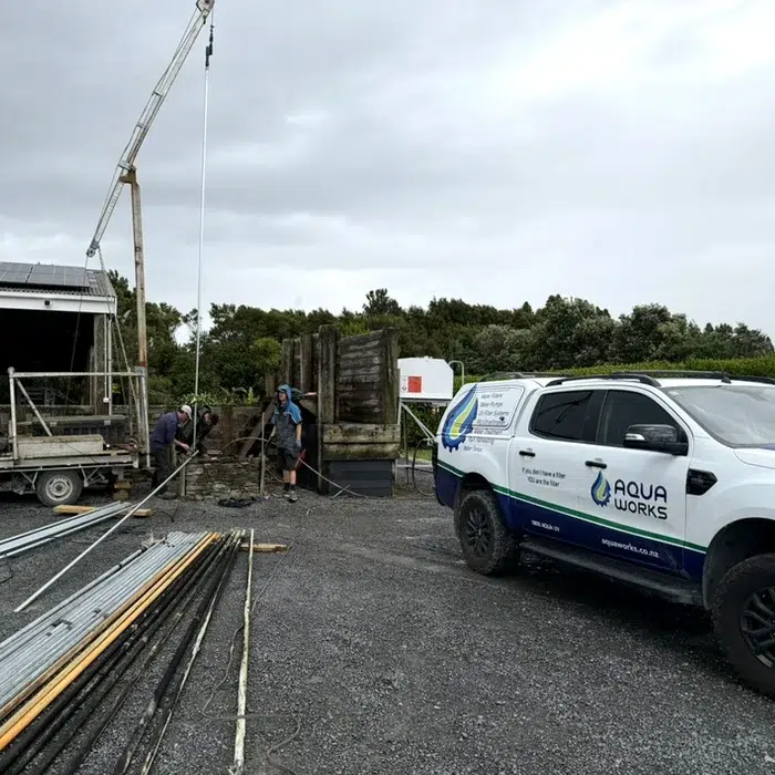 Aqua Works team replacing a bore pump in Helensville with a crane truck, the Aqua Works ute alongside