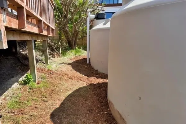 Completed Water Tank Installation – Leigh | Aqua Works Two newly installed rainwater tanks beside a timber deck, with finished landscaping and mulch around the tanks in Leigh.