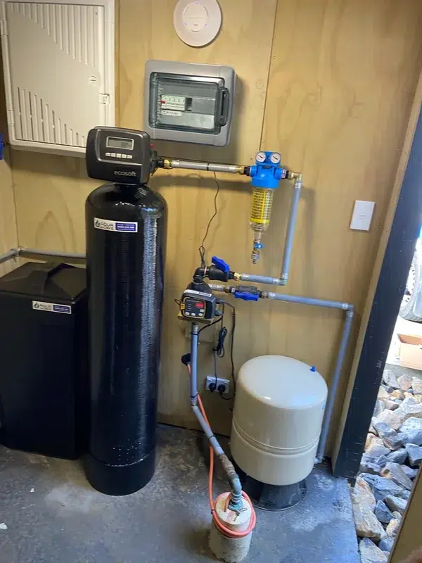 Ecosoft water softener with its salt tank, filter and pressure tank in a pump shed at Sandspit