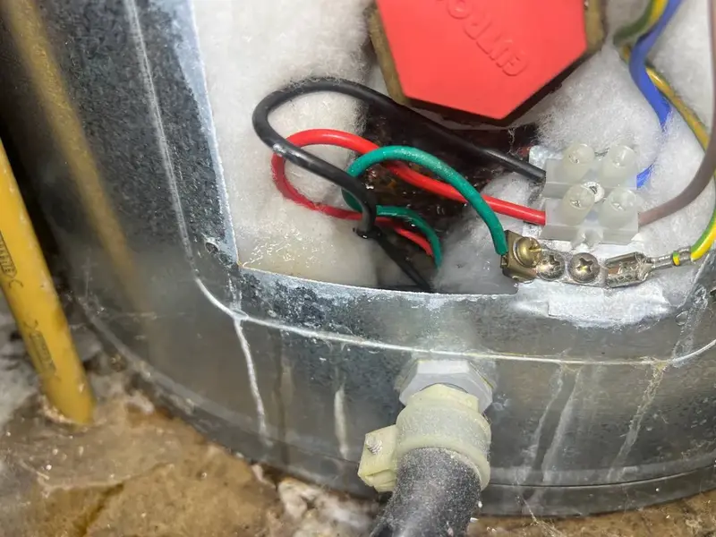 Water damage at the thermostat and element of a leaking hot water cylinder in Army Bay