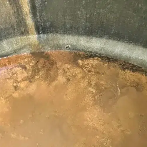 Orange-brown iron sediment in a water tank