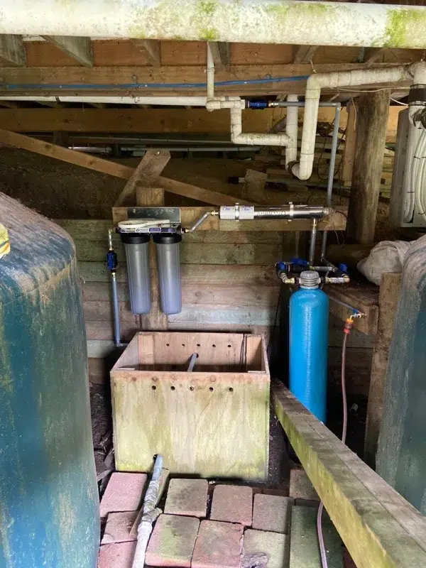 Multimedia filter tank, twin cartridge filters and a UV system under a house in Coatesville
