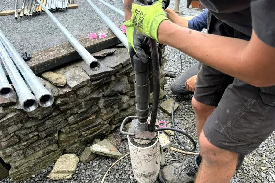 Aqua Works plumber fitting a new bore pump to new galvanised pipe in Helensville