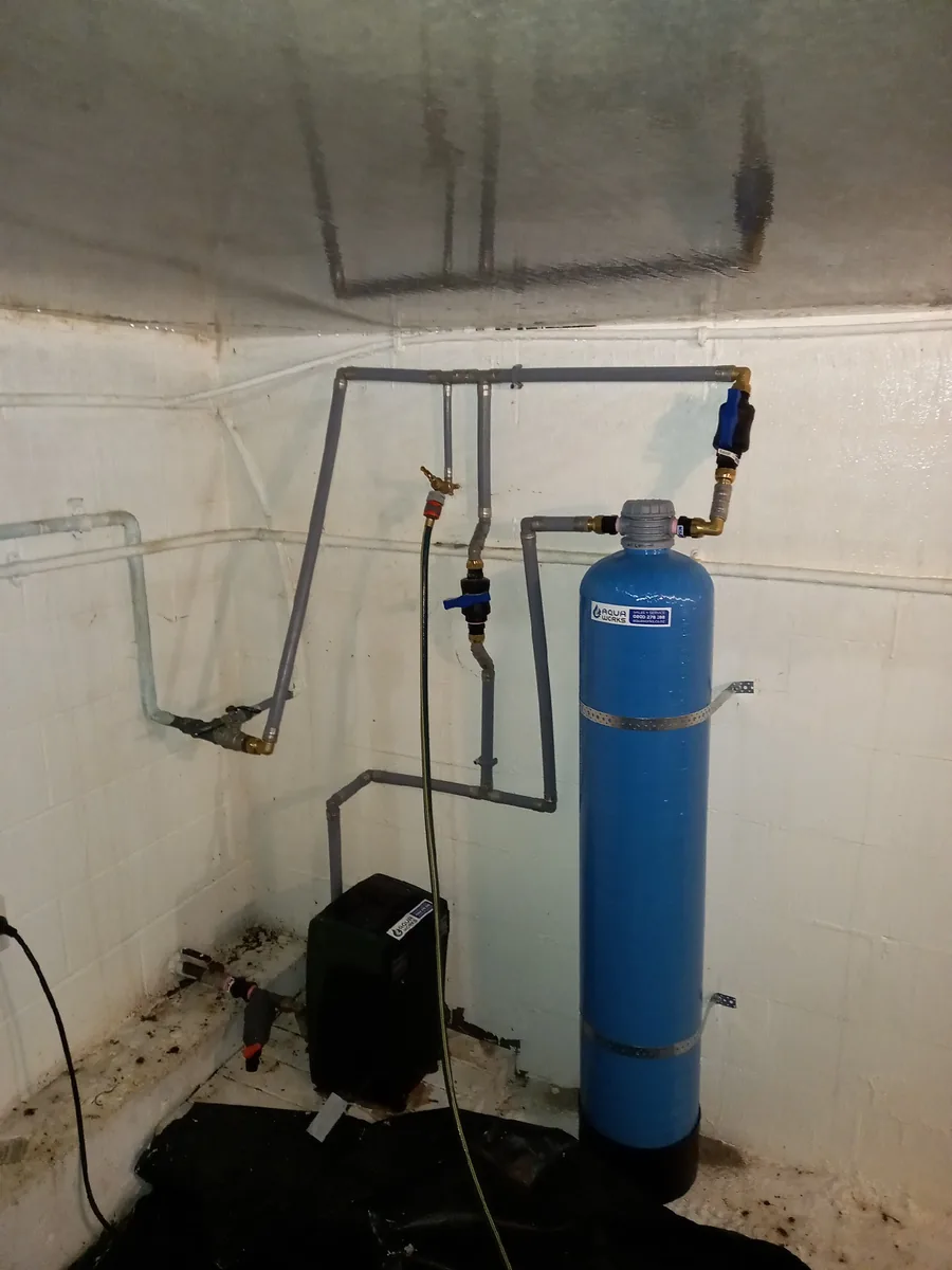 Upflow pH neutraliser with its bypass valves and sample tap, beside the water pump in a concrete pump shed at Stillwater