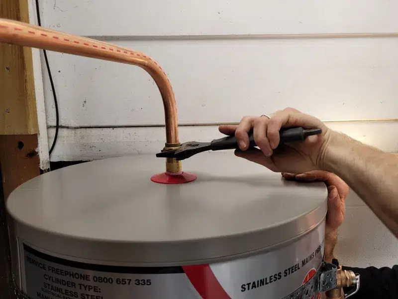 Aqua Works plumber connecting the pipework on top of a new hot water cylinder