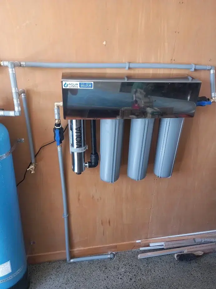 Viqua UV system and three filter housings, including a neutralising filter, on the wall of a home in Mangawhai Heads