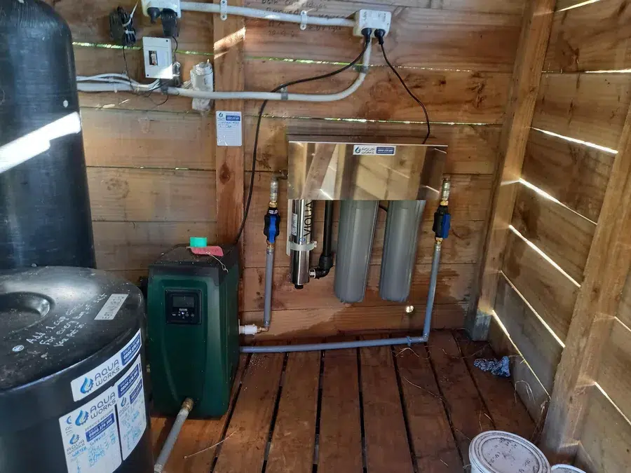 Water softener, pump and UV system with twin filters in a timber pump shed at Mahurangi West