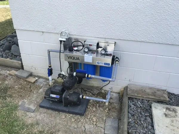Viqua UV system and twin filters on a stainless bracket, with a Grundfos pump on a base, outside a home at Kaipara Flats