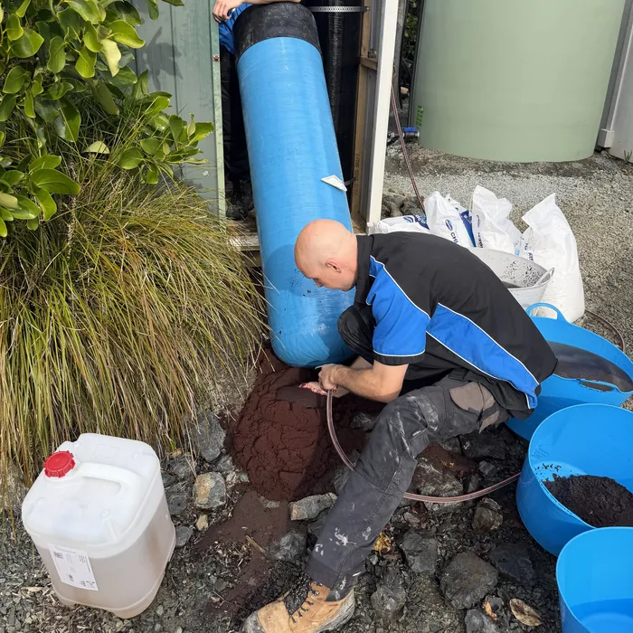 Aqua Works plumbers replacing the resin in a large water softener during a service
