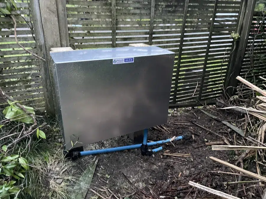 Whole house ioniser hung on two concreted posts near the water meter at a Warkworth home, under a galvanised cover